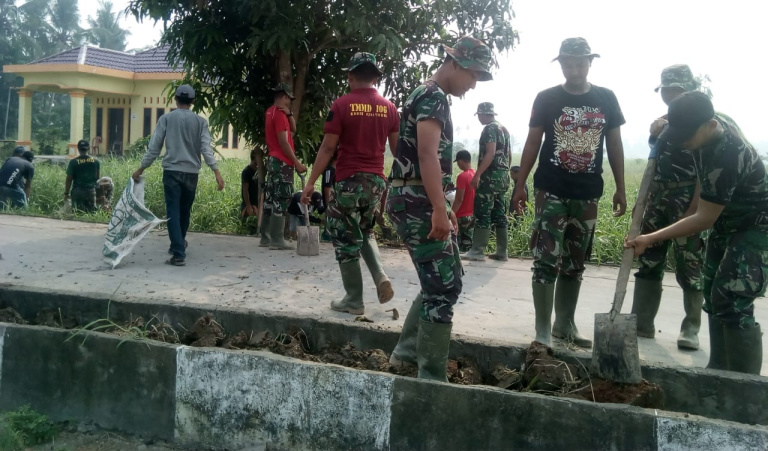 Satgas TMMD Bersama Masyarakat Timbun Median Jalan dengan Tanah
