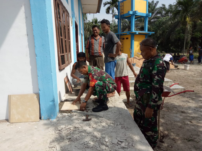 Babinsa Tanjung Penyembal Bantu Pasang Keramik di Musholla Al Muhajirin