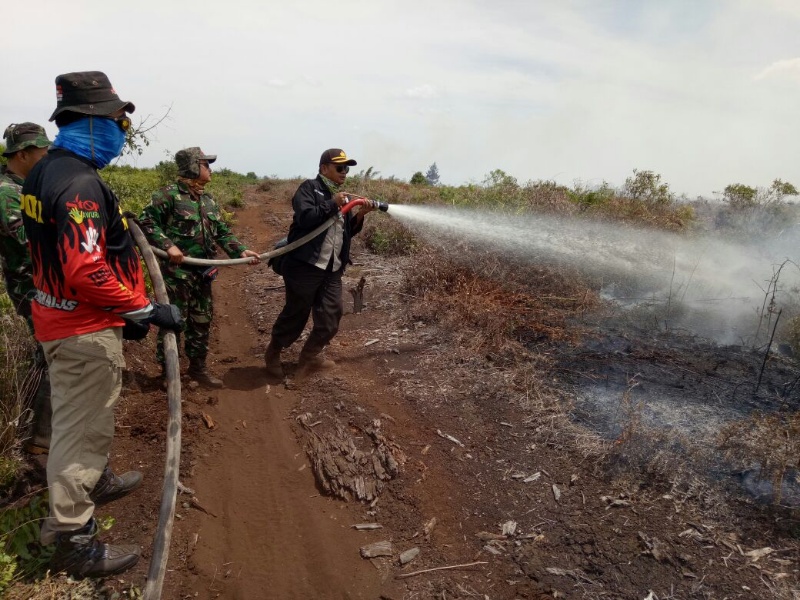 Kapolsek Mandau terjun langsung untuk menjinakkan api yang melahap Lahan dan Hutan Desa Buluh Manis
