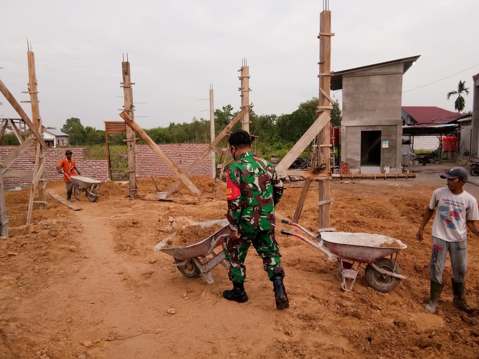 Sertu Mahyudin Bantu Masyarakat Menimbun Pondasi Rumah